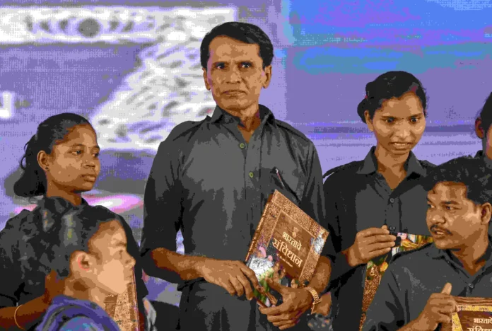 Maoists Bhupathi surrender Senior Maoist leader Mallojula Venugopal Rao alias Bhupathi holds a copy of the Constitution of India as he along with 60 other cadres surrendered before Maharashtra Chief Minister Devendra Fadnavis in Gadchiroli on October 15, 2025. (PTI Photo)